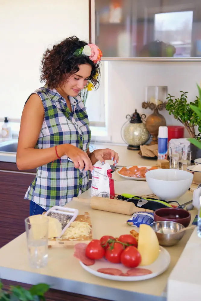 About 2 Sabrine cooking at home with fresh ingredients on the counter.