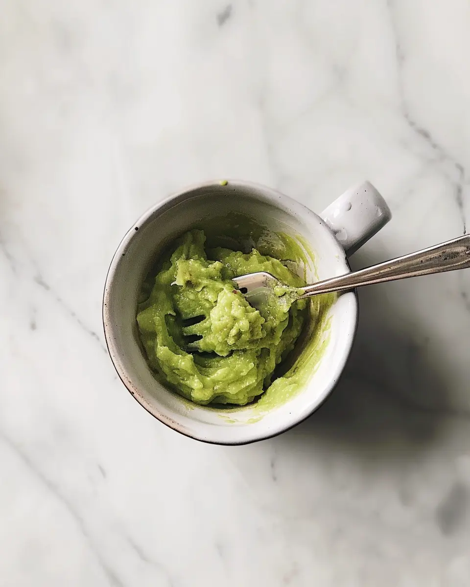 Avocado Chocolate Mug Cake – The Best Healthy Dessert in a Mug 9 Ripe avocado being mashed in a mug with a fork